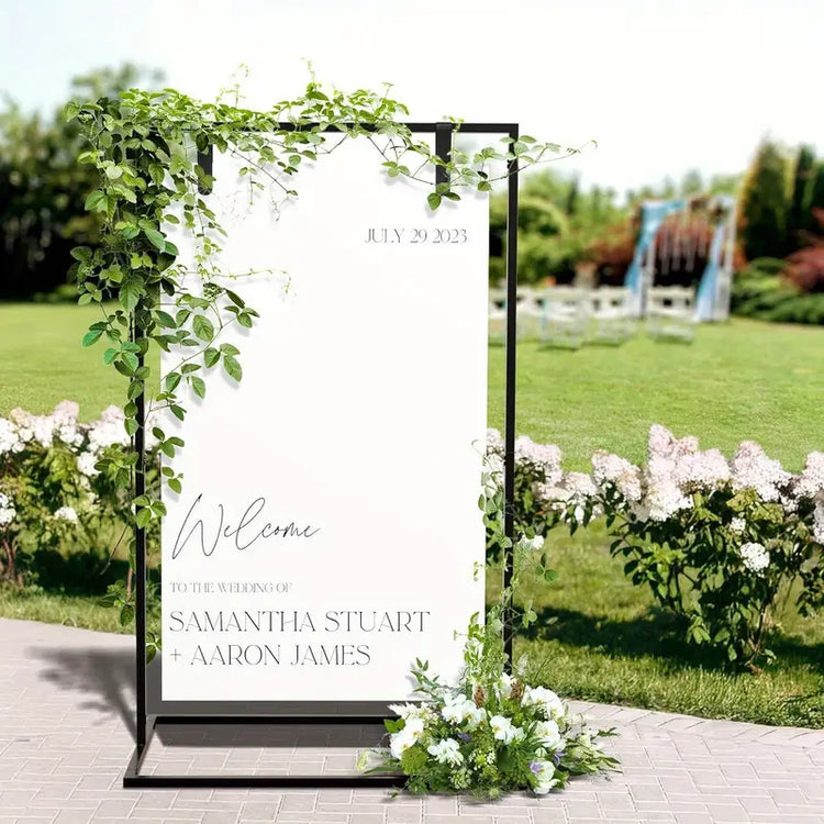 Decorative wedding arch with personalised welcome sign in a garden setting