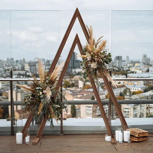 Wooden triangular arch with floral decorations on a rooftop with cityscape view