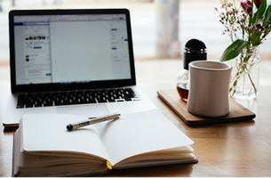 computer with journal and coffee